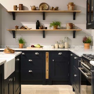 navy Shaker kitchen with chrome cup handles and marble worktops with open kitchen shelving