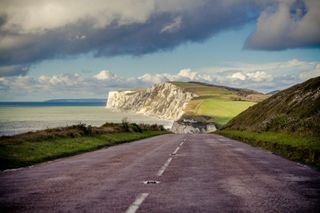 Image shows costal road heading towards Freshwater Bay, Isle of Wight
