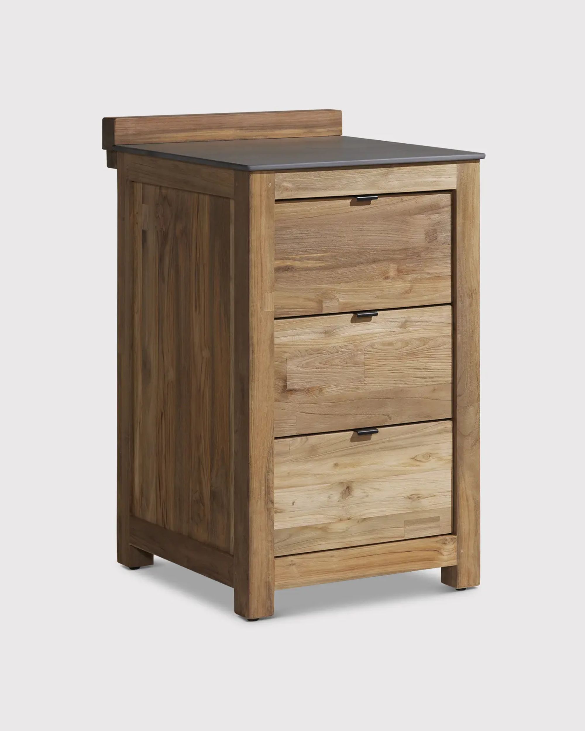 A slim wooden outdoor kitchen unit with three drawers and a dark gray worktop.