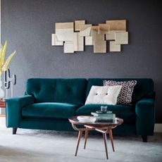 dark green colour java sofa with grey colour wall