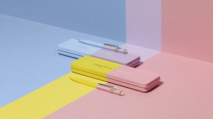 Paul Smith Caran d'Ache pen cases and pens in pink and yellow, and purple and blue