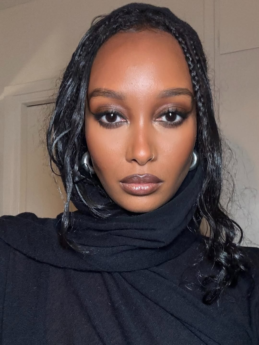 Mona M. Ali with bronzed skin, berry-toned lips, and smoky eye makeup