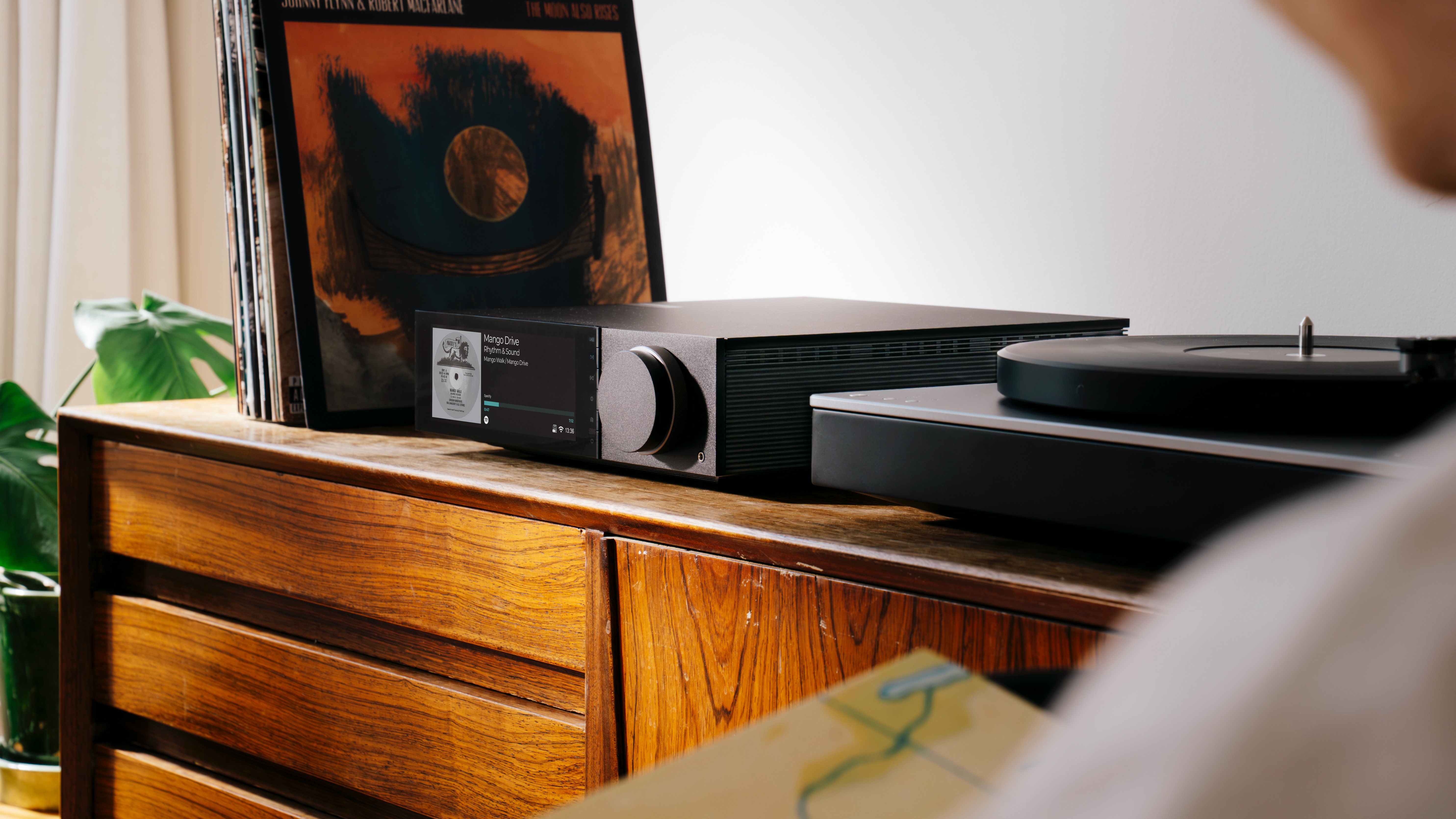 Cambridge Audio Evo 150 SE streaming amplifier in warm living room setting with vinyl records and books
