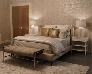Neutral bedroom with gold pillows on white bed