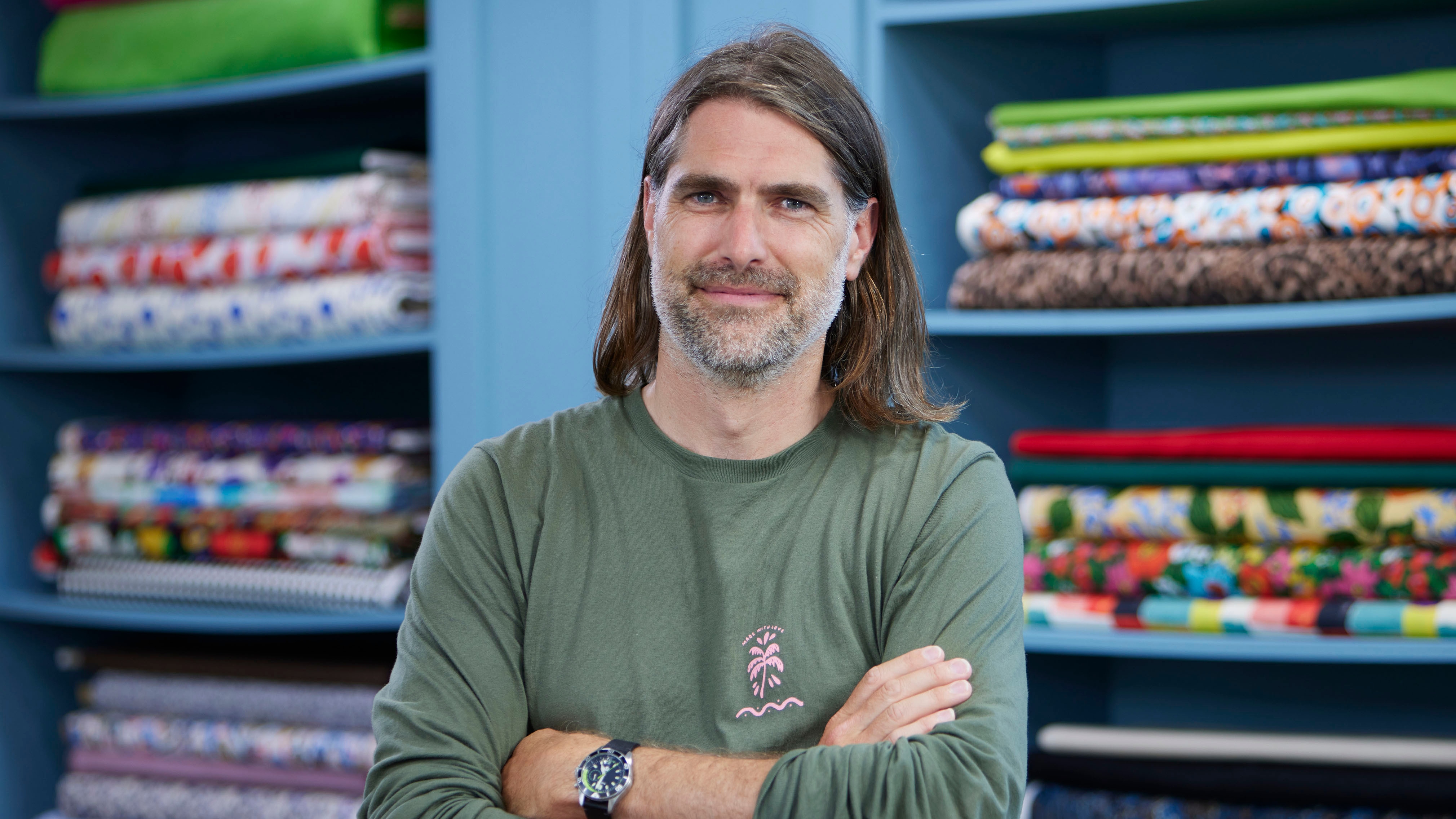 Peter standing in the Great British Sewing Bee studio and smiling for the camera
