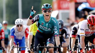 Sam Bennett of Ireland and Team Bora - Hansgrohe raises a finger in celebration of winning a stage of the Vuelta a España cycling race.