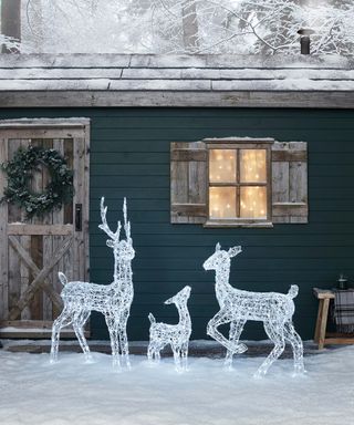 reindeer Christmas outdoor lights in front of a cosy home in the snow