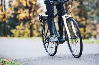 Image shows a person riding an electric bike.