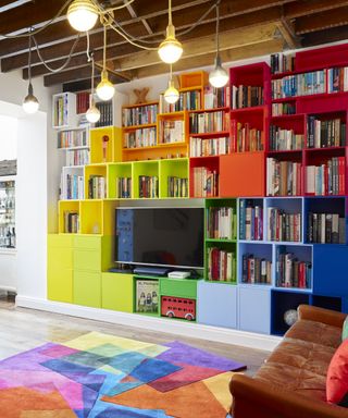 Colorful living room with bookshelf surrounding a mounted TV