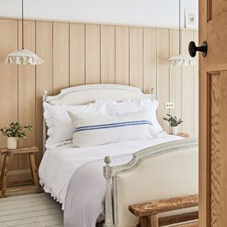 Wooden bedroom with a white bed and white bedding