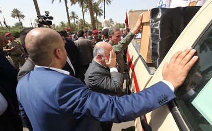 Iraq's prime minister mourns at the coffins of two generals killed by ISIS