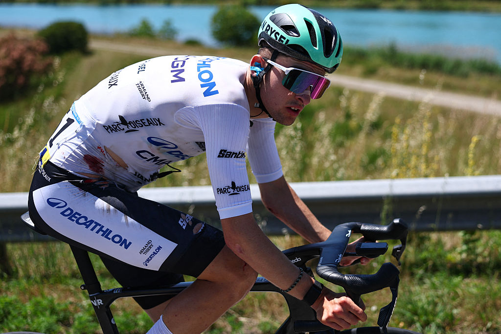 Decathlon CMA CGM Team's French rider Paul Seixas wearing the best young rider's white jersey cycles, bearing visible injuries following a crash, during the 7th stage of the Tour Auvergne-Rhone-Alpes cycling race (formerly known as the Criterium du Dauphine), 133,6km between La Bridoire and Grand Colombier in the French Alps on June 13, 2026. (Photo by Anne-Christine POUJOULAT / AFP)