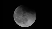 Earth's shadow partially covers the moon as viewed from the ISS