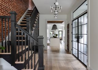 A modern entryway with wooden floors ad black trim