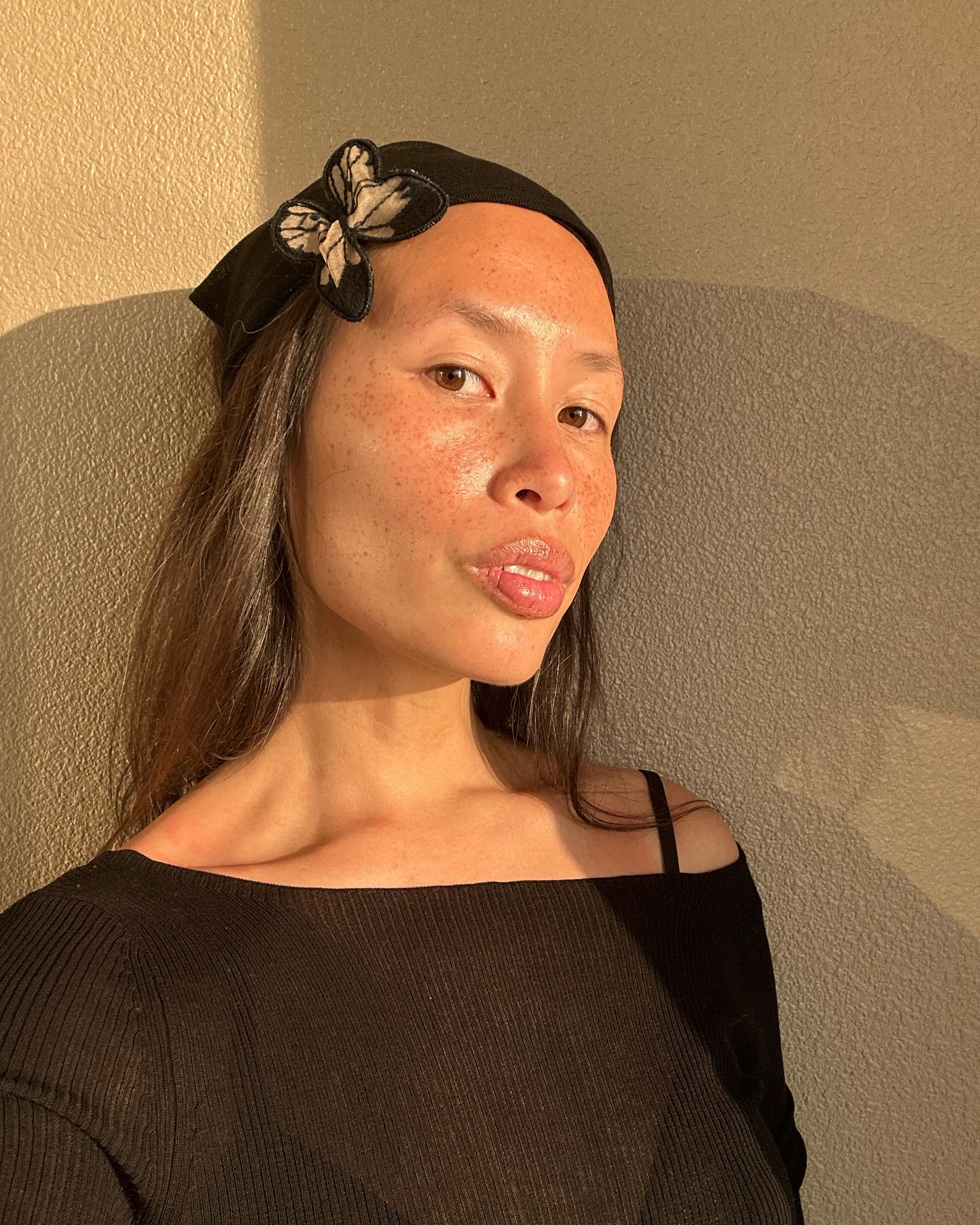Anne-Victoire Lefevre with bright, glowy skin wearing butterfly headband
