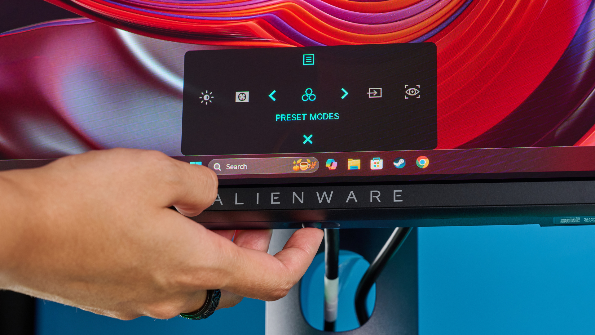 Alienware AW2725D on a desk against a blue background