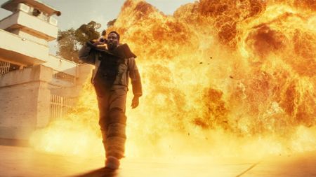 Yahya Abdul-Mateen II as John Creasy, standing in front of a big explosion, in Episode 1 of Man on Fire.