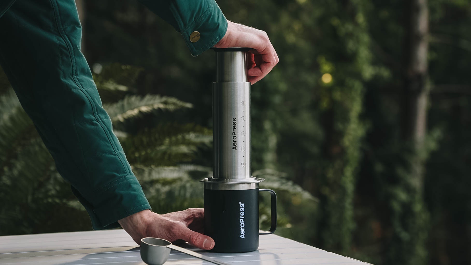 Person using AeroPress Steel coffee maker outdoors