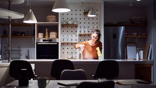woman cleaning kitchen at night
