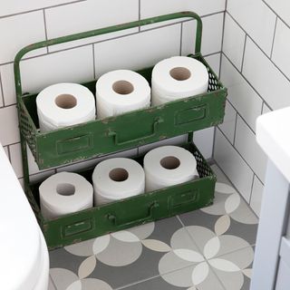 bathroom with flower design tiles and green metal caddy