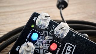 MXR Layers pedal in metallic black finish with clear controls pictured on wood floor with coiled guitar cable