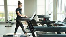 Woman walking on a treadmill in a gym
