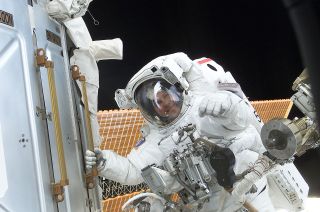 Thomas Jones, STS-98 mission specialist, grabs a hand rail while on a spacewalk outside the International Space Station.