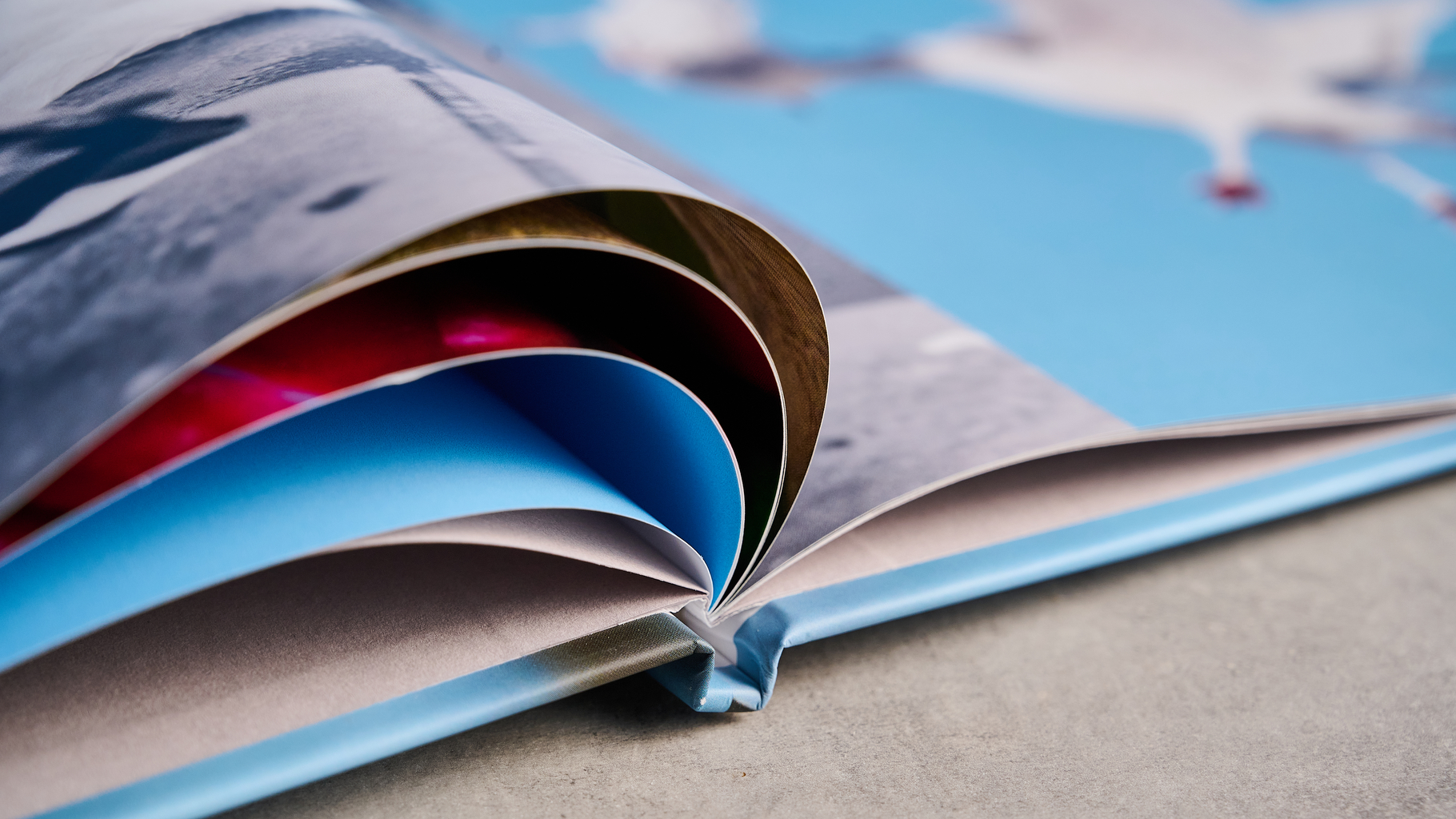 Blurb photo book photographed on a table in front of a blue background