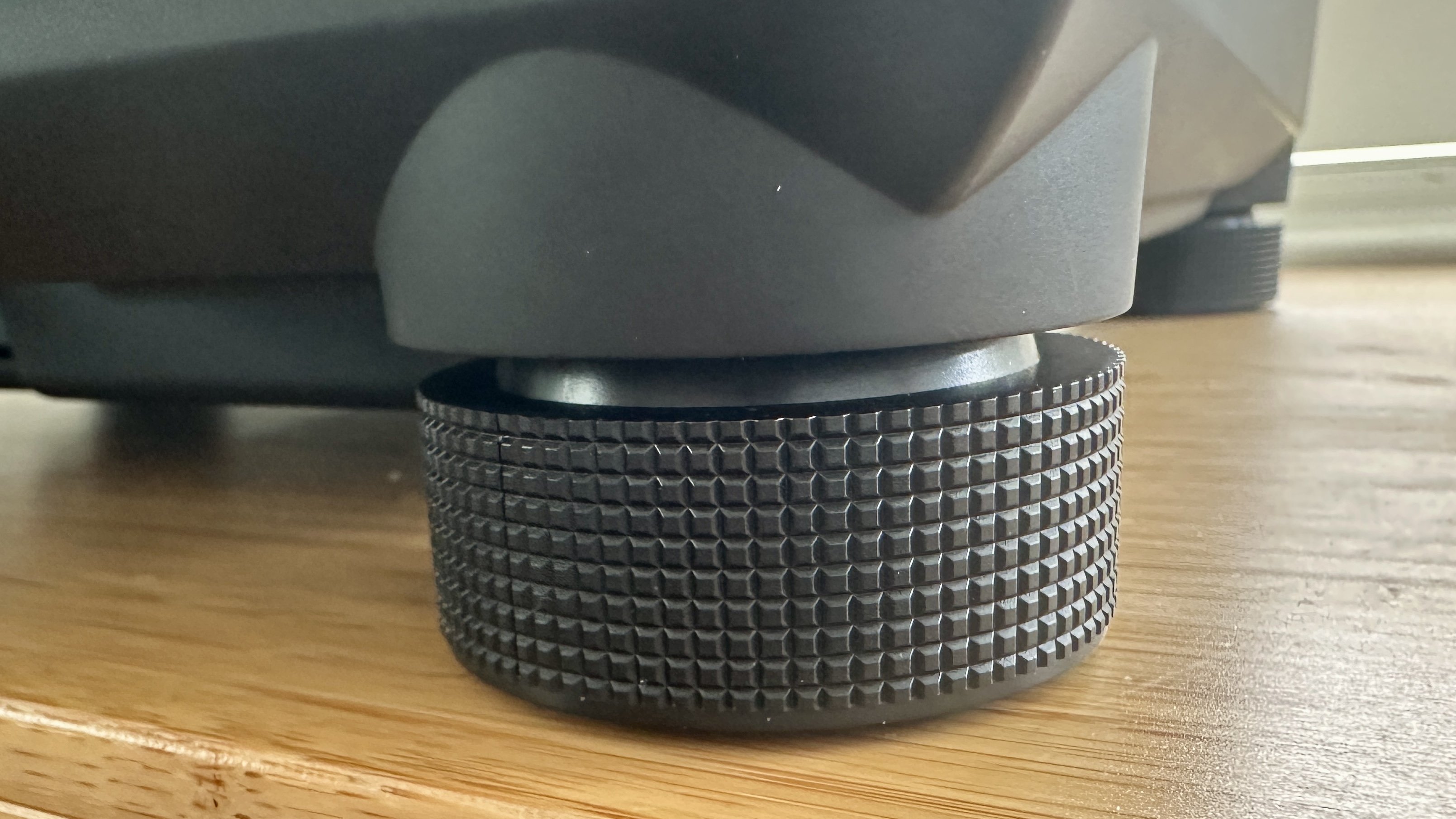 Adjustable feet of the Technics SL-1300G turntable on a wooden surface.