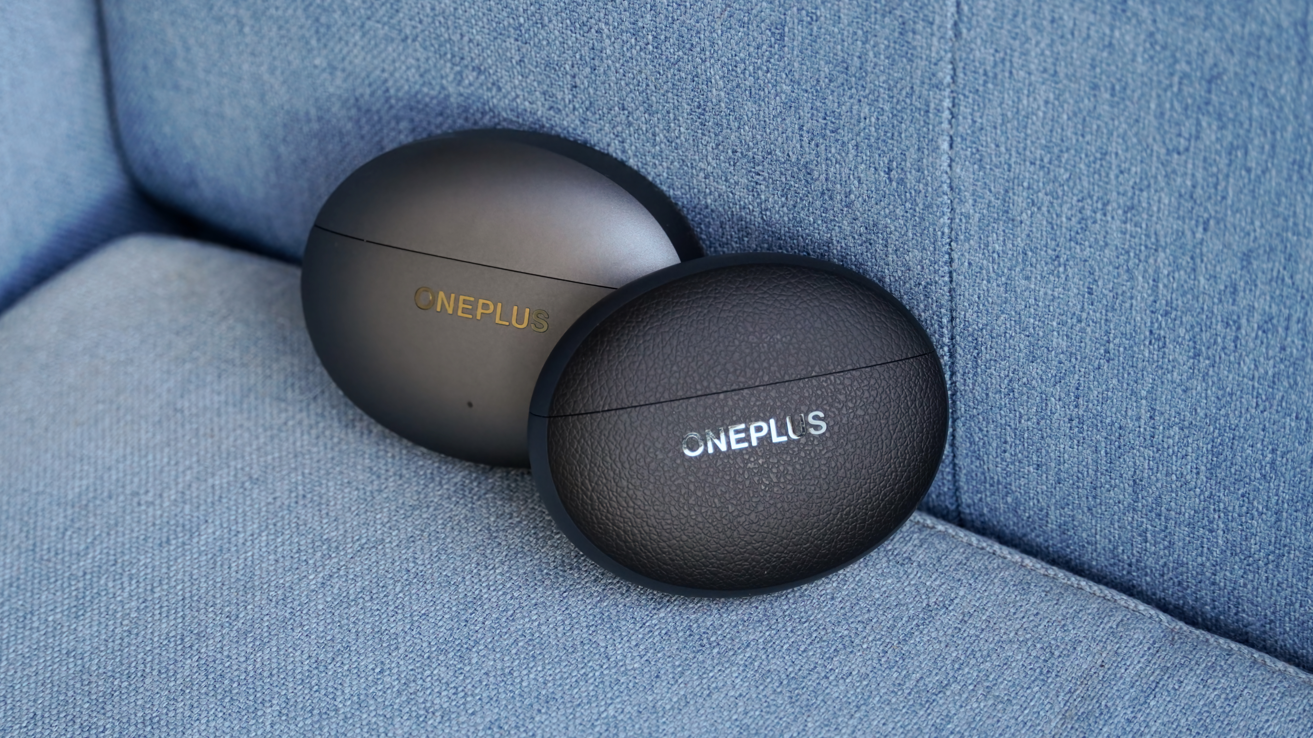 The OnePlus Buds 4 and OnePlus Buds Pro 3 cases next to each other.
