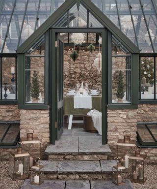 Glass outbuilding, steps up to entrance deocrated in lanterns and festive decorations