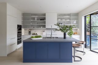 minimalist kitchen with a blue island and grey floor