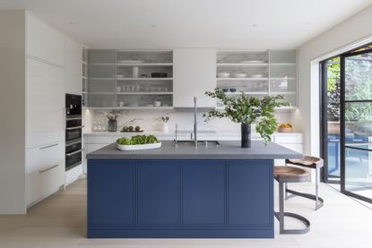 minimalist kitchen with a blue island and grey floor