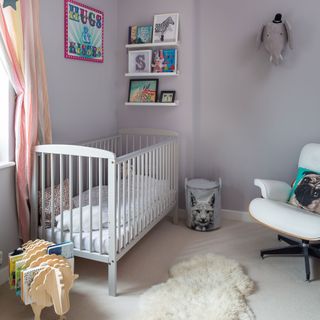 Purple nursery with white cot, fluffy rug, book storage and armchair