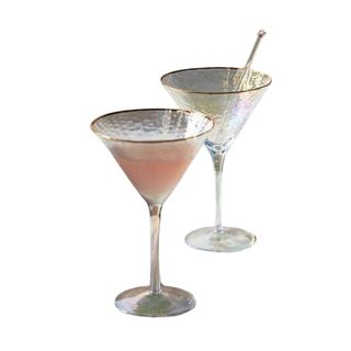 Two martini cocktail glasses with gold rims, with one filed with peach colored liquid