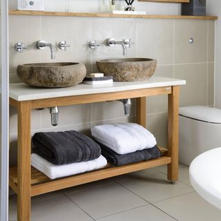 bathroom with open shelving and towels under sink
