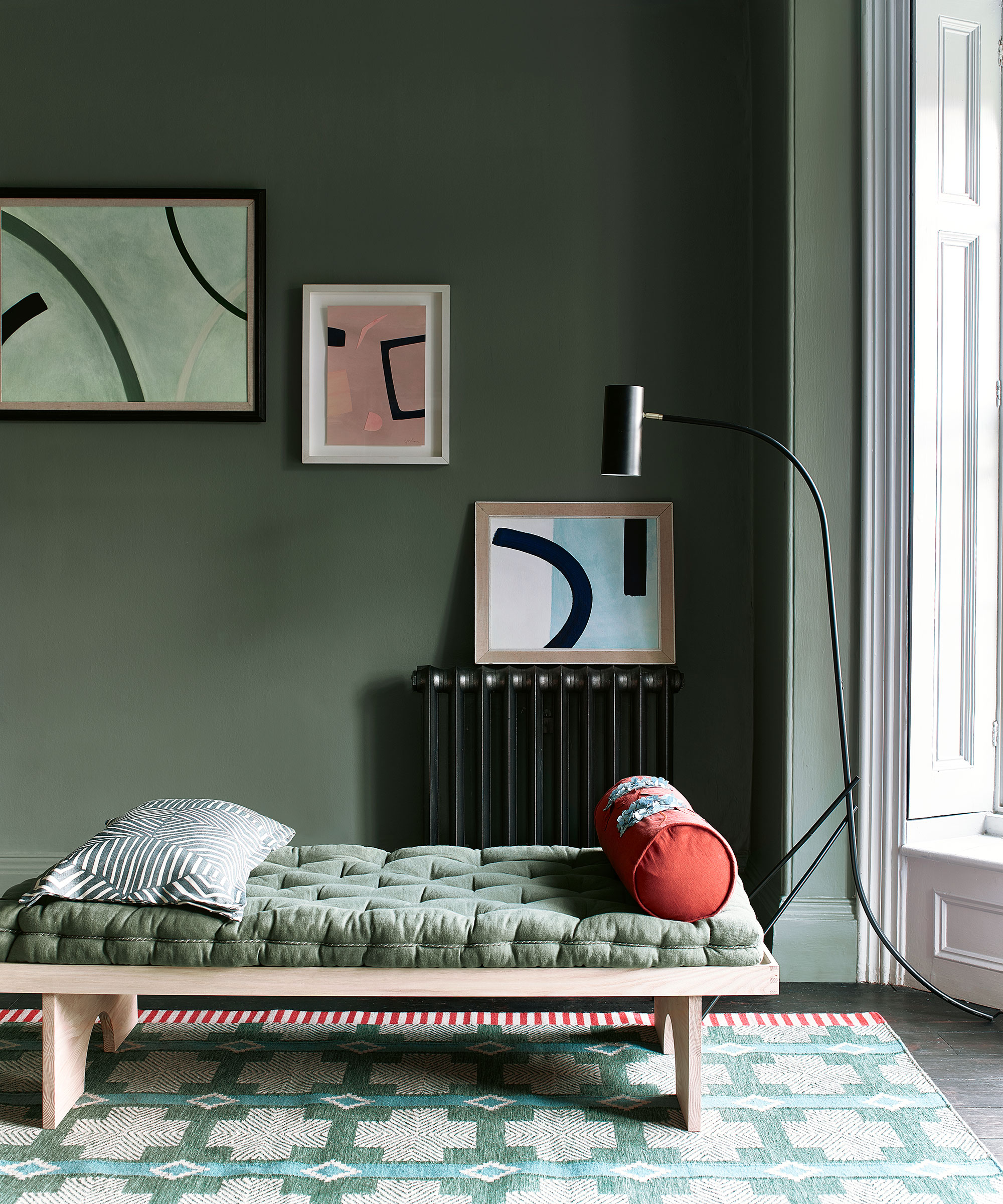 Dark living room with green paint and gallery wall