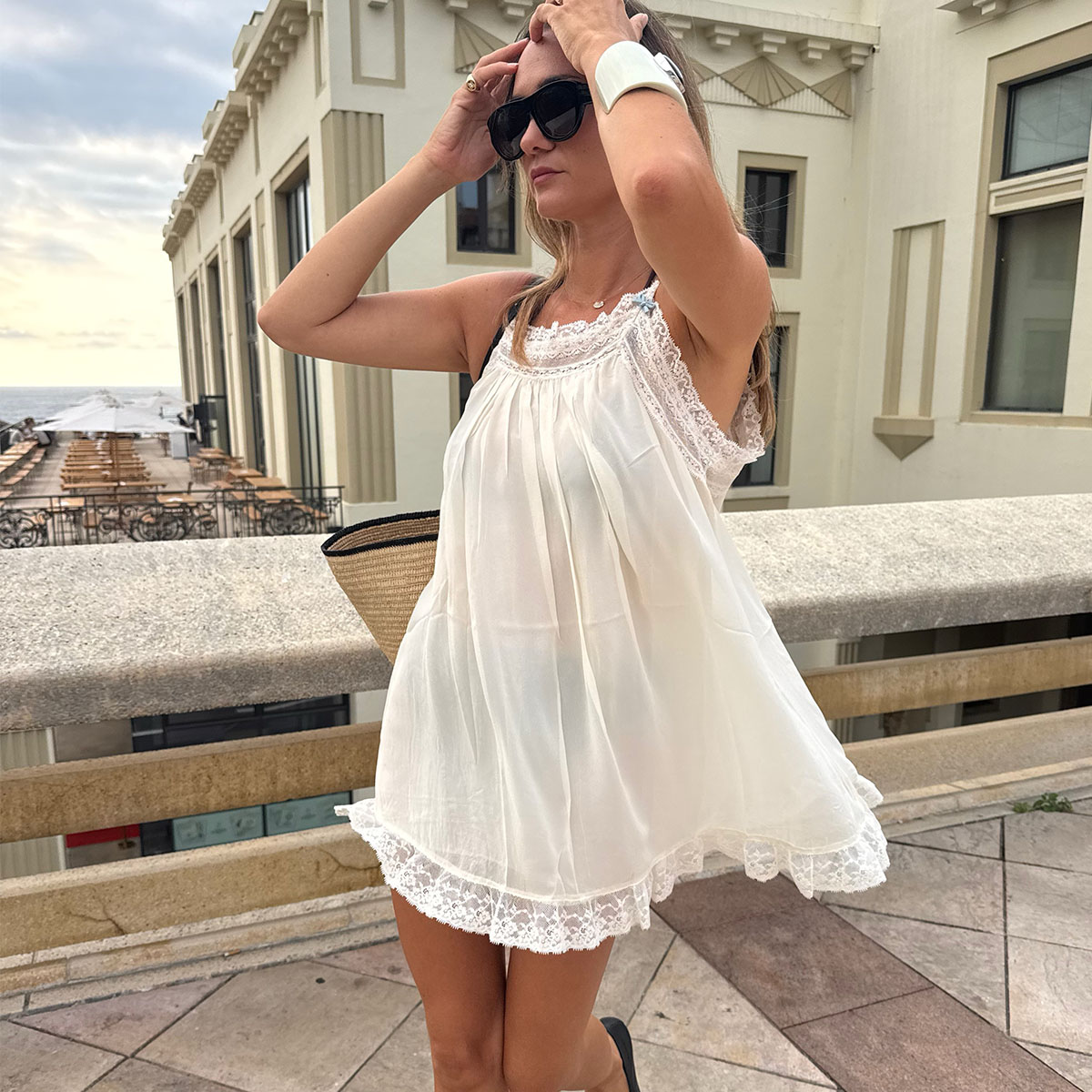 Woman in a white babydoll dress and ballet flats