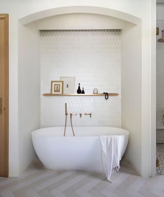 bathroom nook carved out to fit a freestanding bathtub with shelving