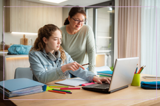 Mum helping daughter with homework on computer