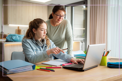 Mum helping daughter with homework on computer