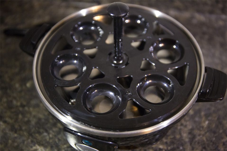 You situate eggs in the plastic rack above the water reservoir to cook them to soft-, medium- or hard-cooked consistency.