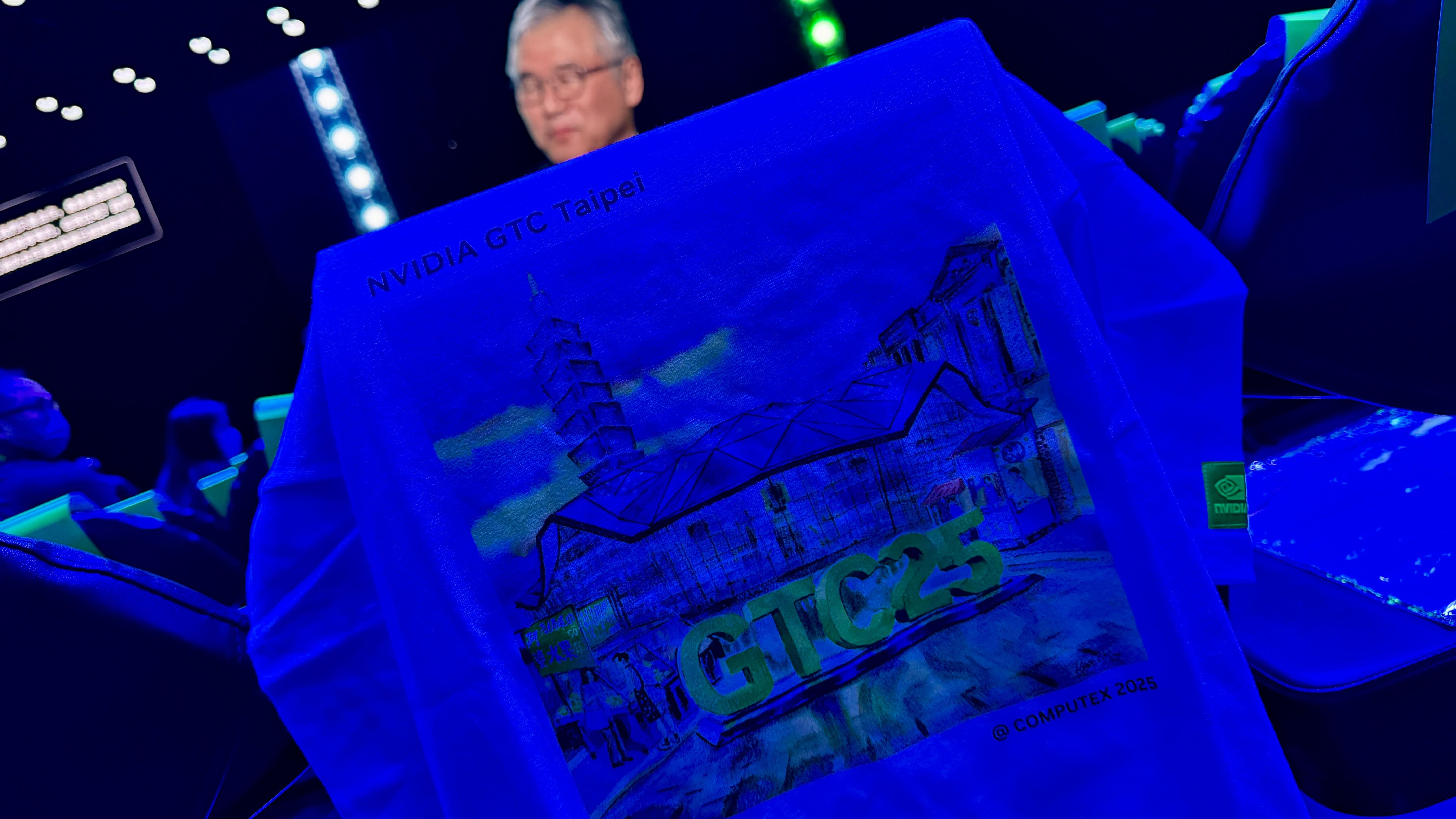 Nvidia Computex 2025 t-shirt on seat with view of screen behind