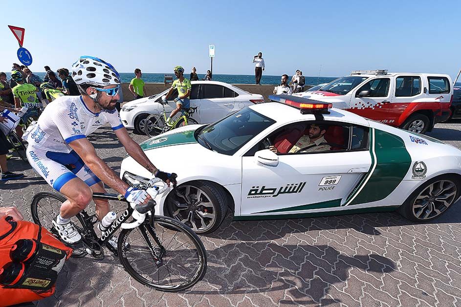 A Novo Nordisk rider negotiates one of the police cars