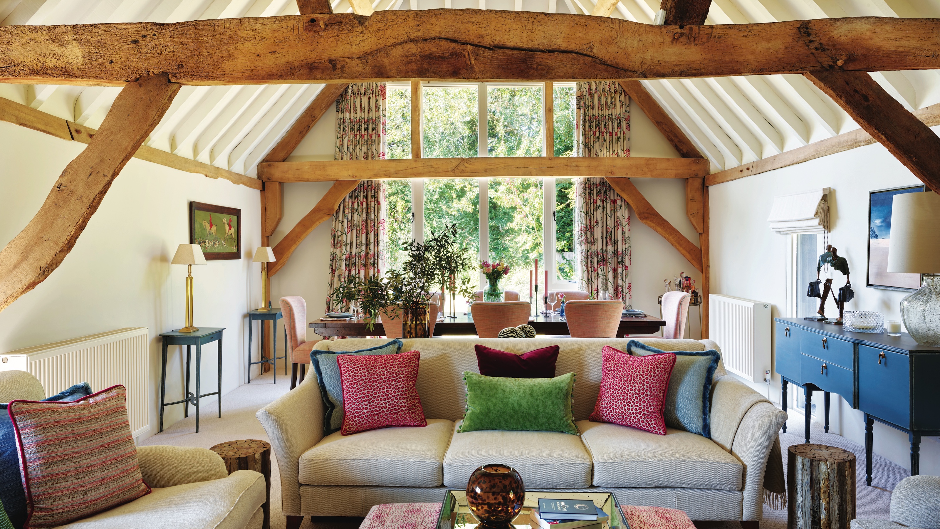 living room in barn conversion with vaulted beamed ceiling and cream sofa
