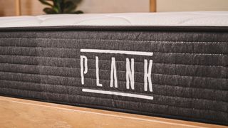 A closeup of the Plank logo the right way up at the end of the Plank Firm mattress