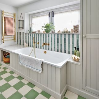 Bathroom with bath and green and white striped tiles