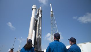 NASA astronauts Suni Williams, left, Barry "Butch" Wilmore, center, and Mike Fincke, right, watch as a United Launch Alliance Atlas V rocket with Boeing’s CST-100 Starliner spacecraft aboard is rolled out of the Vertical Integration Facility to the launch pad at Space Launch Complex 41 ahead of the Orbital Flight Test-2 (OFT-2) mission, Wednesday, May 18, 2022, at Cape Canaveral Space Force Station in Florida.