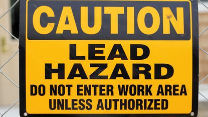 Yellow lead hazard sign with black text.