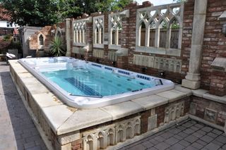 stone lined above ground swimming pool in traditional style